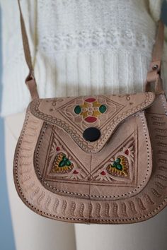 Vintage cute little Ethnic handmade saddle bag in sepia beige color. Colorful ornament front. Flap cover with push pin. Adjustable shoulder strap with buckle. Measurements: 6" x 5", 50" handle Condition: excellent! Bohemian Brown Satchel As Gift, Bohemian Brown Satchel For Gift, Bohemian Brown Satchel As A Gift, Traditional Brown Crossbody Satchel, Traditional Brown Leather Saddle Bag, Traditional Brown Satchel Saddle Bag, Traditional Leather Saddle Bag, Traditional Hand Tooled Shoulder Bag As A Gift, Handmade Brown Bohemian Saddle Bag