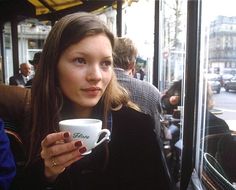 a woman holding a coffee cup in her right hand