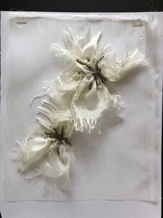 two pieces of white cloth with frayed edges