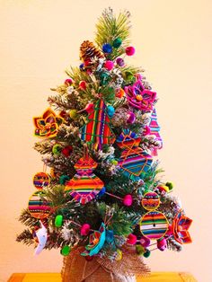 a decorated christmas tree sitting on top of a wooden table