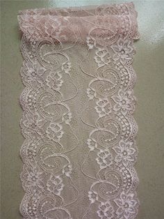 an image of a white lace on the wall with pink trimmings and flowers