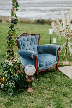 a blue chair sitting on top of a lush green field next to a wooden pole