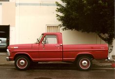 a red pick up truck parked in front of a building