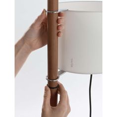 a person is holding a lamp with one hand and pulling it up to the other