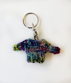 a crocheted keychain is hanging on a white surface