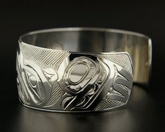 "This extraordinary hand-engraved cuff depicts the 'Raven Stealing the Light' myth: \"At the beginning of time, the whole world was dark. The reason for this blackness had to do with an old man in a house by one of the largest rivers on Earth, who had a box, which contained a box, which contained a box, which contained an infinite number of boxes, each nestled in a box slightly larger than itself until finally there was a box so small all it could contain was all the light in the universe. The o Symbolic Formal Jewelry With Etched Details, Formal Symbolic Etched Jewelry, Symbolic Engraved Cuff Bangle Bracelet, Symbolic Etched Cuff Bracelet Bangle, Symbolic Etched Cuff Bracelet, Symbolic Etched Bangle Cuff Bracelet, Symbolic Engraved Ceremonial Cuff Bracelet, Symbolic Engraved Cuff Bracelet For Ceremonies, Ceremonial Polished Cuff Bangle Bracelet