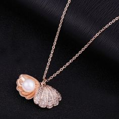 Seashell Pave Cubic Zirconia & Pear Rose Gold Necklace Metal: Zinc Alloy + Rose Gold Plated Measurements: Pendant: 0.6in Chain: 18in Elegant Shell-shaped Rose Gold Jewelry, Elegant Rose Gold Shell-shaped Jewelry, Beachy Gold Shell-shaped Necklace, Gold Ocean-inspired Shell Necklace, Gold Shell-shaped Necklace With Pearl Chain, Clam Pearl, Ocean-inspired Gold Shell With Pearl Pendant, Rose Gold Pearl Necklace, Preppy Jewelry