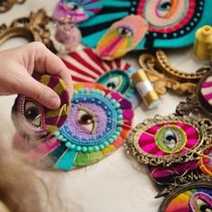 a person is holding something in their hand near some colorful items that are on the table