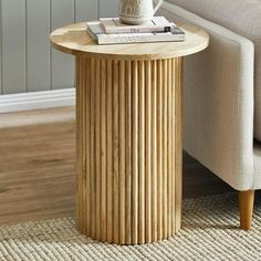 a wooden table sitting on top of a rug next to a couch