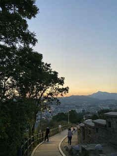 people are walking up and down the stairs to the top of a hill at sunset