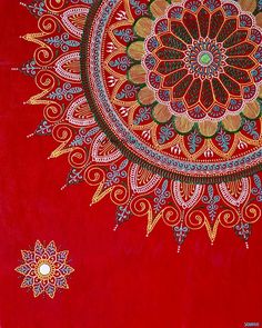 a red blanket with an intricate design on it's side and two stars in the middle