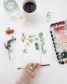 someone is painting flowers with watercolors on paper