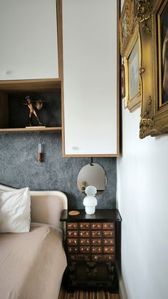 a bedroom with a bed, dresser and mirror on the wall next to each other