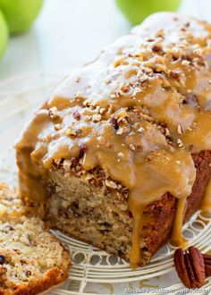 a loaf of bread covered in caramel glaze and pecans on a plate