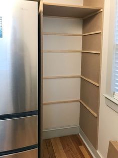 a stainless steel refrigerator freezer sitting inside of a kitchen next to a wooden floor