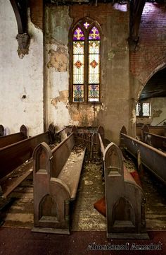 an old church with stained glass windows and pews in the foreground is empty