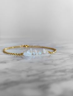 Lunar. This delicate bracelet is composed of genuine tiny raw moonstone, 14K gold vermeil delicate sparkly chain and components. Such a magically dainty piece! This elegant piece combines beautifully classic and minimalist style. Perfect as a gift to someone born in June, as moonstone is June birthstone! ❈ We send all our items with registered mail. ❉ Due to the organic nature of stones, there might be a slight variation in colour, size and shape. ✺ All items come packaged in a quality velvet po Gold Beaded Bracelets With Moonstone, Gold Moonstone Bracelets With Natural Stones, Minimalist Gold Beaded Bracelets For Healing, Dainty Moonstone Bracelets With Natural Stones, Handmade Minimalist Gold Crystal Bracelet, Dainty Moonstone Bracelet With Natural Stones, Handmade Minimalist Crystal Bracelet, Minimalist Crystal Bracelet With Natural Stones For Everyday, Minimalist Moonstone Bracelets With Natural Stones