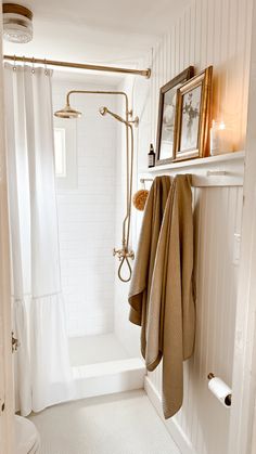 a bathroom with a shower, towel rack and white tile flooring is pictured in this image