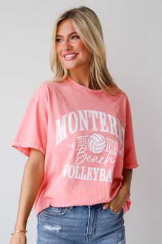 Introducing the Monterey Beach Volleyball Coral Graphic Tee, a must-have addition to your casual wardrobe for those sunny days and laid-back weekends! Crafted from soft, breathable cotton fabric, this tee offers both comfort and style, making it perfect for any outdoor adventure or relaxed outing. Featuring a vibrant coral color, this tee instantly adds a pop of brightness to your ensemble, while the playful graphic print of a beach volleyball scene captures the essence of carefree coastal livin Pink Sporty Tops For Beach Season, Sporty Pink Tops For Beach Season, Moisture-wicking Crew Neck Top For Beach, Athleisure Short Sleeve Tops For Vacation, Athleisure Short Sleeve Beach Tops, Sporty Pink Tops For Vacation, Sporty Pink Top For Vacation, Sporty White Tops For Beach Season, Collegiate Summer T-shirt