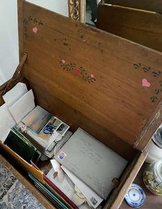 an old wooden box filled with lots of papers and other items on top of a table