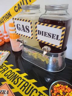 there is a table with candy in jars and caution tape on the table next to it