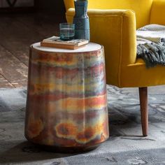 a yellow chair sitting next to a table on top of a rug