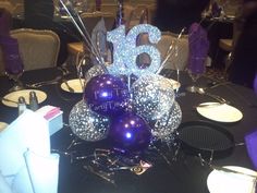 the table is set with purple and silver decorations for a birthday party or special occasion