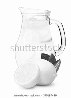 a pitcher filled with lemonade next to sliced lemons and mint on a white background