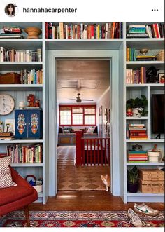 an open door leading to a living room with lots of bookshelves and furniture