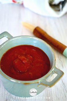 there is a small bowl of red sauce on the table next to some cinnamon sticks