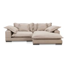 a white couch with pillows on it and a footstool in front of it