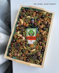 a wooden box filled with assorted nuts and an alcohol bottle in the top right corner