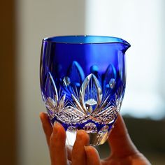 a person holding a blue glass in their hand