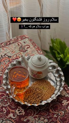 there is a tea pot and two cups on the table with food in front of it