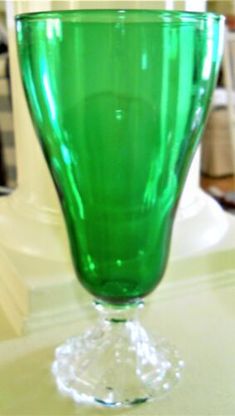 a green glass sitting on top of a table