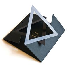 three folded black and silver cards on top of each other with the letter m in the middle