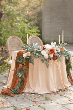 a table with flowers and candles on it is set up for an outdoor wedding reception