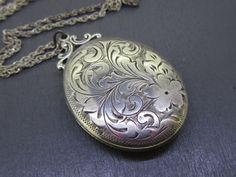 Beautiful antique sterling silver oval locket that comes with a vintage (not original to the locket but still vintage) 18" sterling silver chain.  Locket opens and closes great!  Light age related wear and patina on the locket, some small dings on the back.  Has the original photos inside but no frames/covers.  Visit Ribbons Edge for more great pieces of vintage and antique jewelry!  All items added to your cart at Ribbons Edge will automatically combine shipping. To stay up to date with my newe Antique Silver Sterling Silver Vintage Locket Necklace, Vintage Sterling Silver Engraved Locket Necklace, Vintage Engraved Sterling Silver Locket Necklace, Antique Silver Necklace With Vintage Charm, Antique Silver Necklace With Vintage Charm In Oval Shape, Antique Silver Necklaces With Oval Vintage Charm, Antique Silver Oval Necklace With Vintage Charm, Silver Oval Vintage Style Necklace, Vintage Silver Medallion Locket Necklace