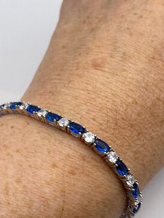 This Blue Iolite bracelet is very lively and bright.  The stones are deep colors and well matched.  The sterling silver is plated with rhodium to protect the bracelet from tarnish and give the appearance of white gold. 7 inches for a smaller wrist  All jewelry is shipped in a nice gift box.   Check out our over a THOUSAND great reviews Engraving is $4 per letter and is not always perfect depending on the piece. It can take a few days if the jeweler is busy. This is payable to Paypal Judithsltd@g Sapphire Sterling Silver Bracelet, Sapphire Cubic Zirconia Tennis Bracelet With Gemstone, Blue Sterling Silver Bracelet With Polished Finish, Blue Sterling Silver Bracelets With Polished Finish, Blue Sapphire Bracelets For Anniversary, Classic Sapphire-colored Cubic Zirconia Bracelets, Silver Sapphire Bracelets For Anniversary, Classic Silver Sapphire Bracelets, Silver Sapphire Bracelet For Anniversary