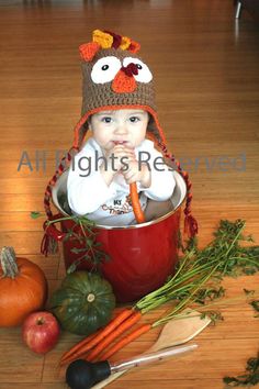 a baby is sitting in a pot with carrots and other vegetables