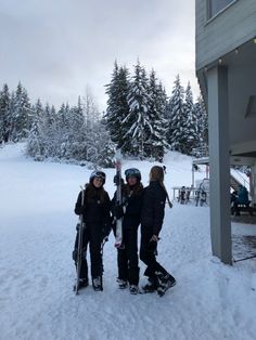 three people standing next to each other in the snow