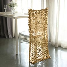 a gold chair sitting in front of a table with a vase on top of it