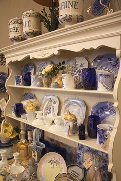 an old china cabinet with blue and white dishes on it