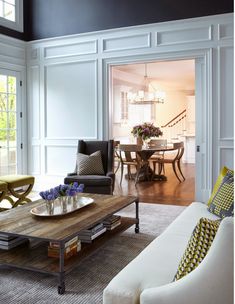 a living room filled with furniture and a wooden coffee table on top of a hard wood floor