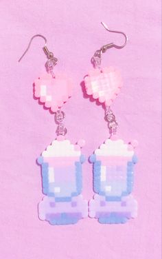 two pink and blue cupcakes are hanging from earrings