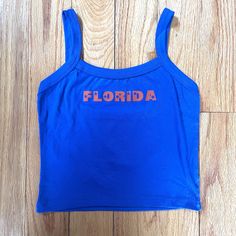 Florida blue and orange tank with star lettering. Perfect for a tailgate or showing spirit! Orange Tops For Women, Casual Tops With Team Name For Tailgating, Blue Sleeveless Collegiate Tops, Collegiate Blue Sleeveless Tops, Orange Casual Tank Top For Sports, Blue Sleeveless Collegiate Style Top, Casual Orange Tank Top For Sports, Blue Graphic Print Sporty Tank Top, Sporty Blue Tank Top With Graphic Print