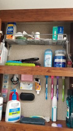 an organized bathroom cabinet with toothbrushes, shampoos and other hygiene products