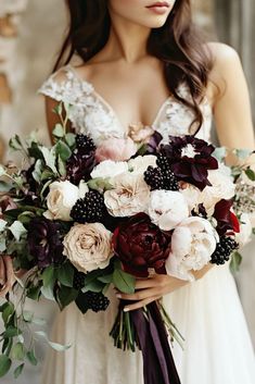 a woman in a wedding dress holding a bridal bouquet with red and white flowers