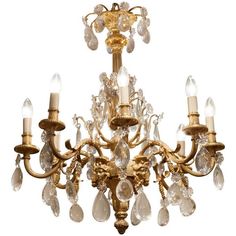 a gold chandelier with crystal drops hanging from it's center and sides