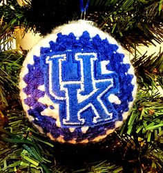 a blue and white ornament hanging from a christmas tree